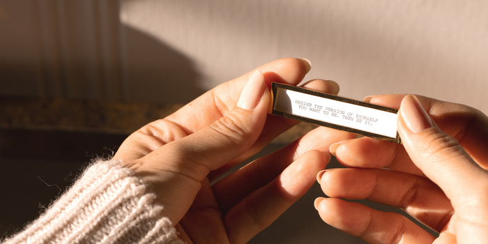 Hands holding the Fortune Frame with an affirmation quote.